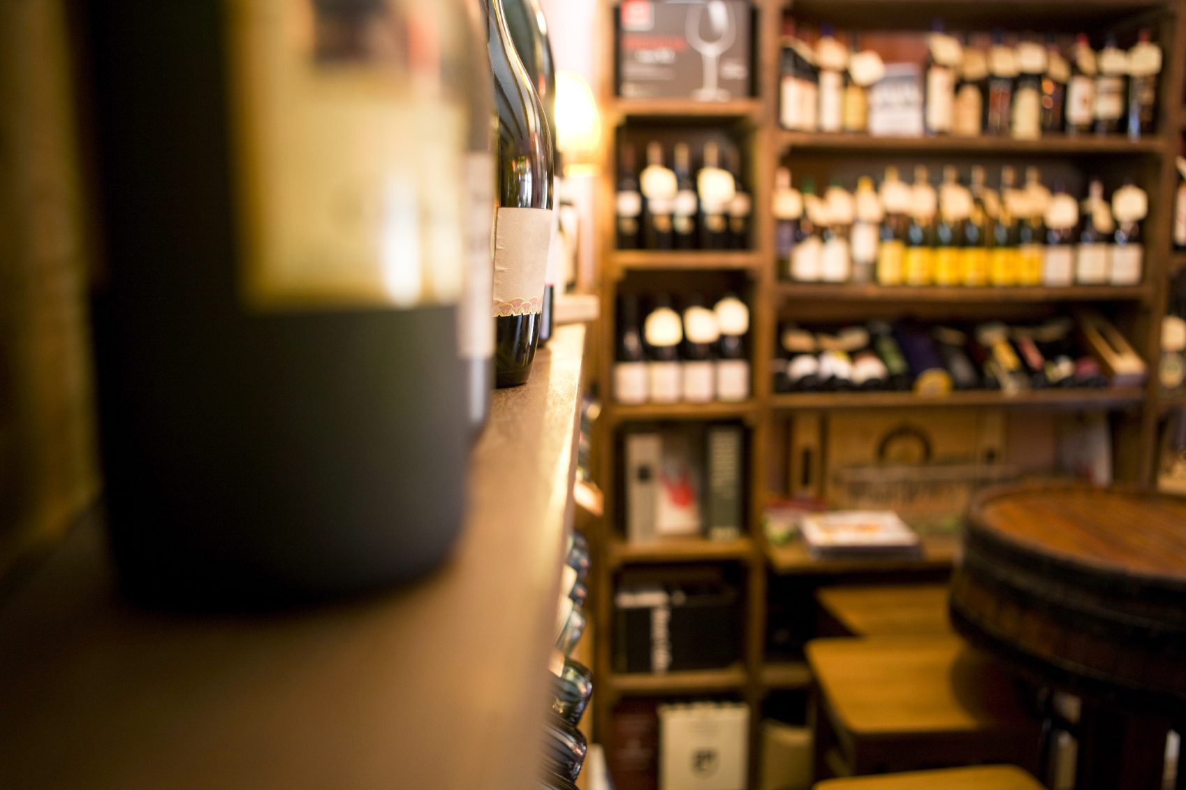 Rayonnage de vin avec bouteilles et caisses en bois dans une cave.